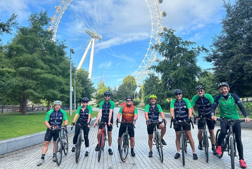 lots of people on bikes in front of a ferris wheel